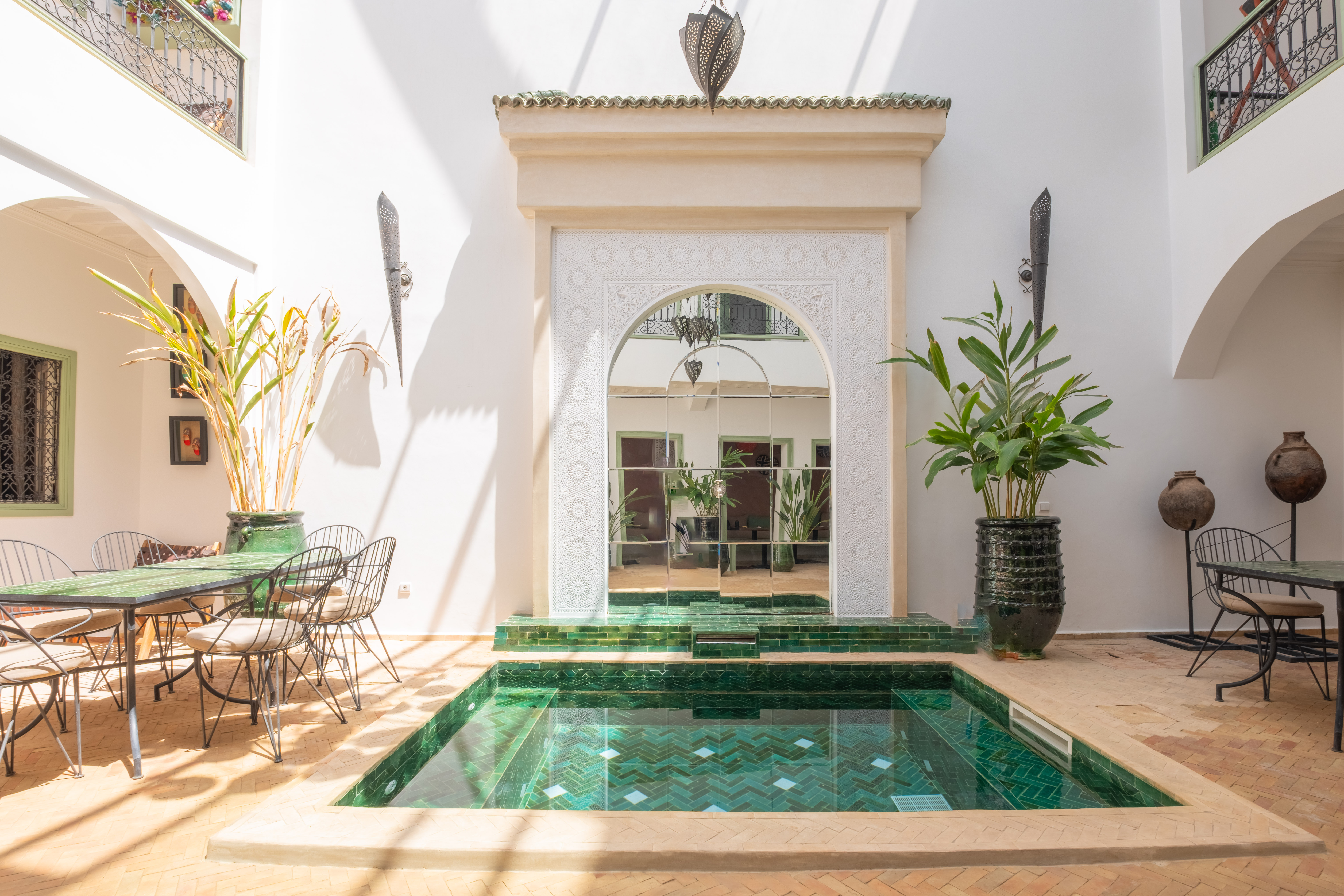 Indoor pool and patio beneath an arch at Riad Thaïs in Marrakech